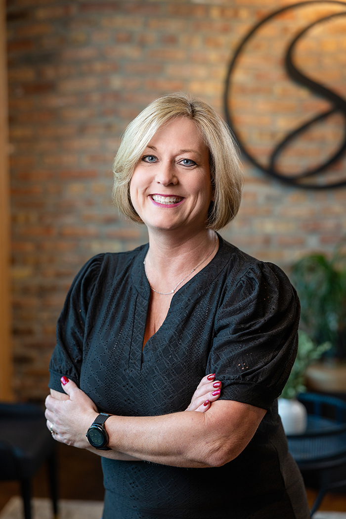 Helen-Noonan_stylist-TheStrandSalonandSpa Helen Noonan, stylist, standing posed for a portrait in side The Strand Salon and Spa in Columbia, Missouri where she does hair.